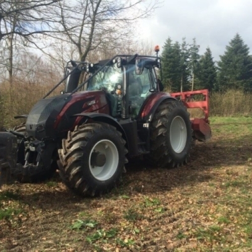 Traktor med skovfræser til maskinskovning og knusning af grene og bevoksning.