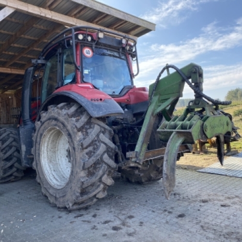 Kævletang monteret på traktor bruges til løft og håndtering af træstammer i skovarbejde.